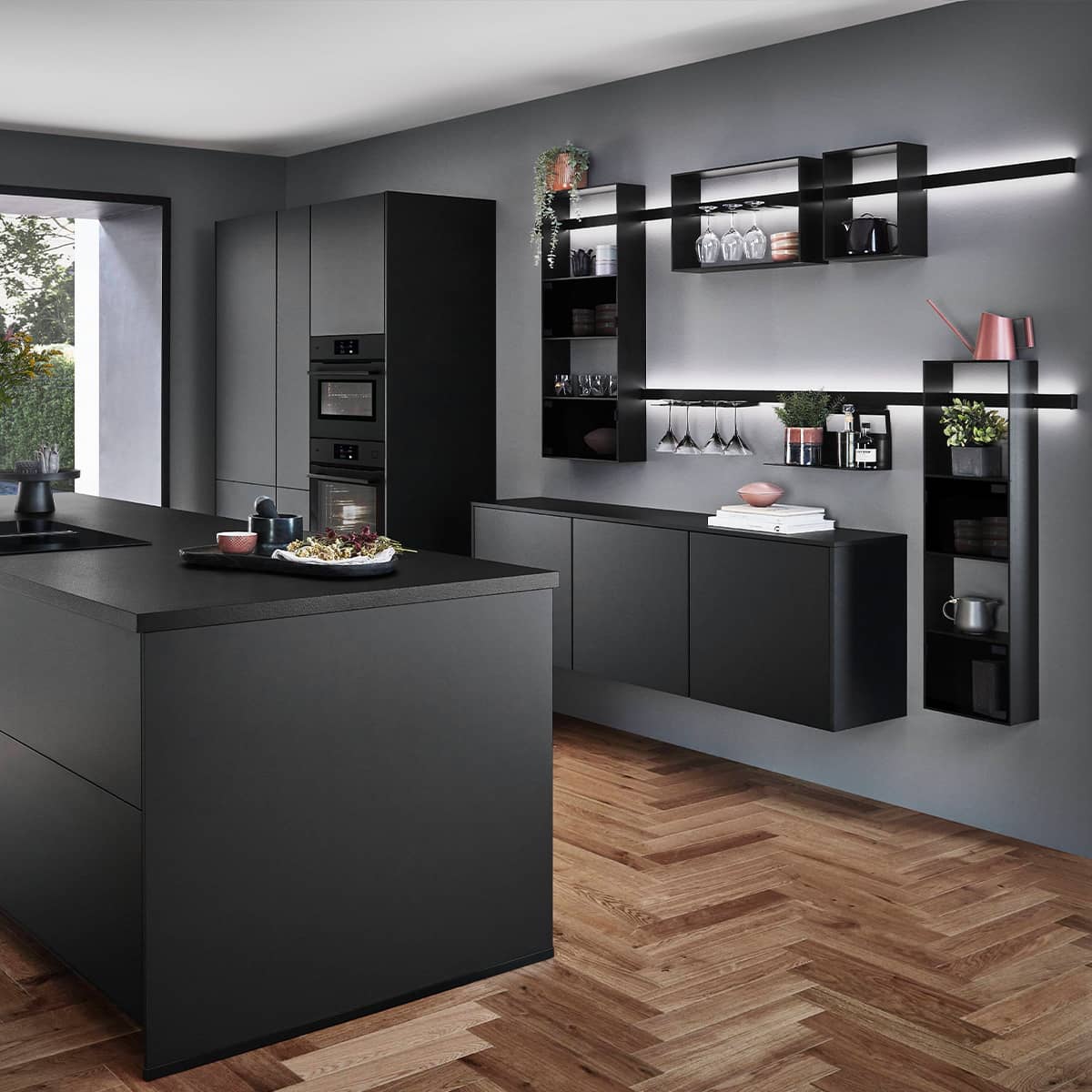 Minimalist black supermatt kitchen featuring TOUCH 340 cabinets, Smartcube wall-hung shelving, and integrated black ovens.