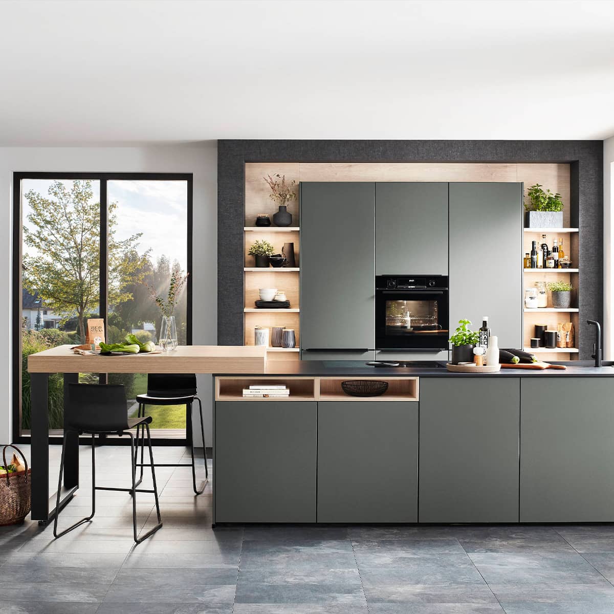 Mineral Green kitchen with wooden shelving, an island, and light coming through a sliding door.