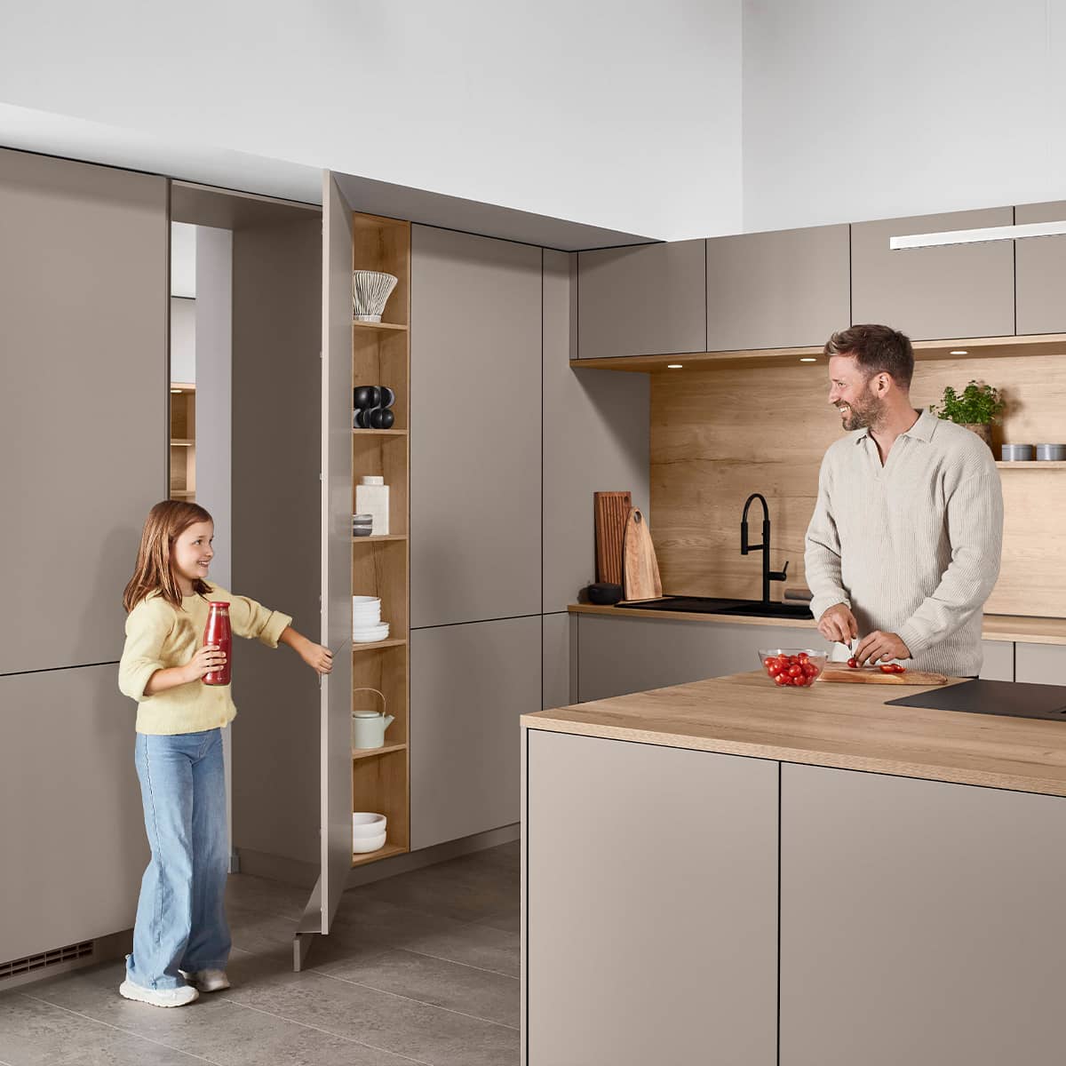 Senso Kitchen 483 - Hidden Pantry Modern taupe handleless kitchen featuring a secret walk-in pantry hidden behind cabinet doors with integrated wooden shelving.