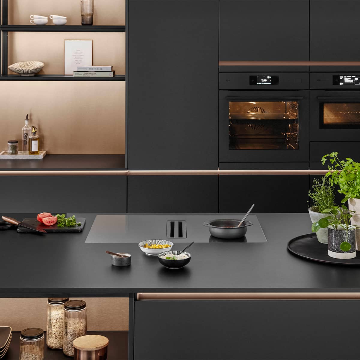 Senso Kitchen 496 - The ultimate black kitchen Luxury matte black kitchen design featuring rose gold or copper recessed handle tracks, integrated black ovens, and an induction cooktop.