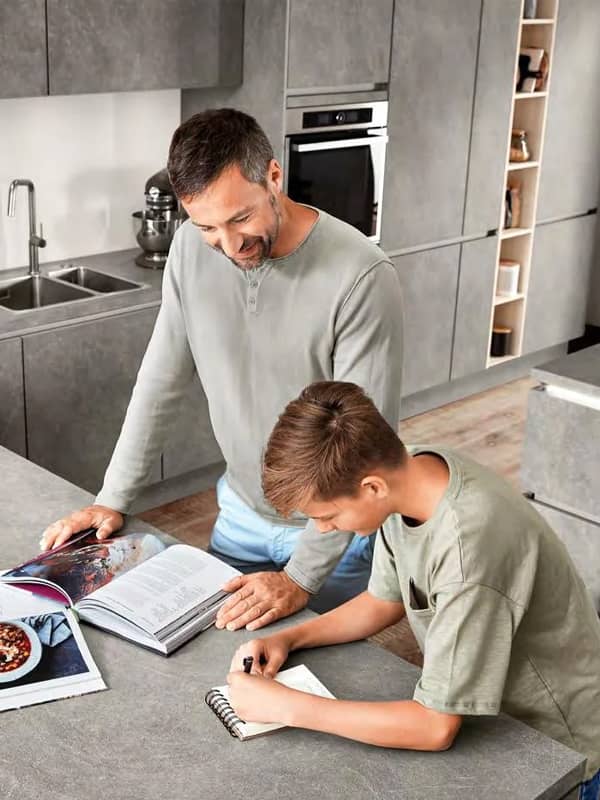 Family in grey slate kitchen with wood tones