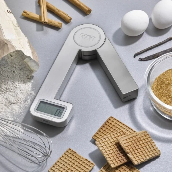 caso small stainless steel scale on a table top surrounded with food