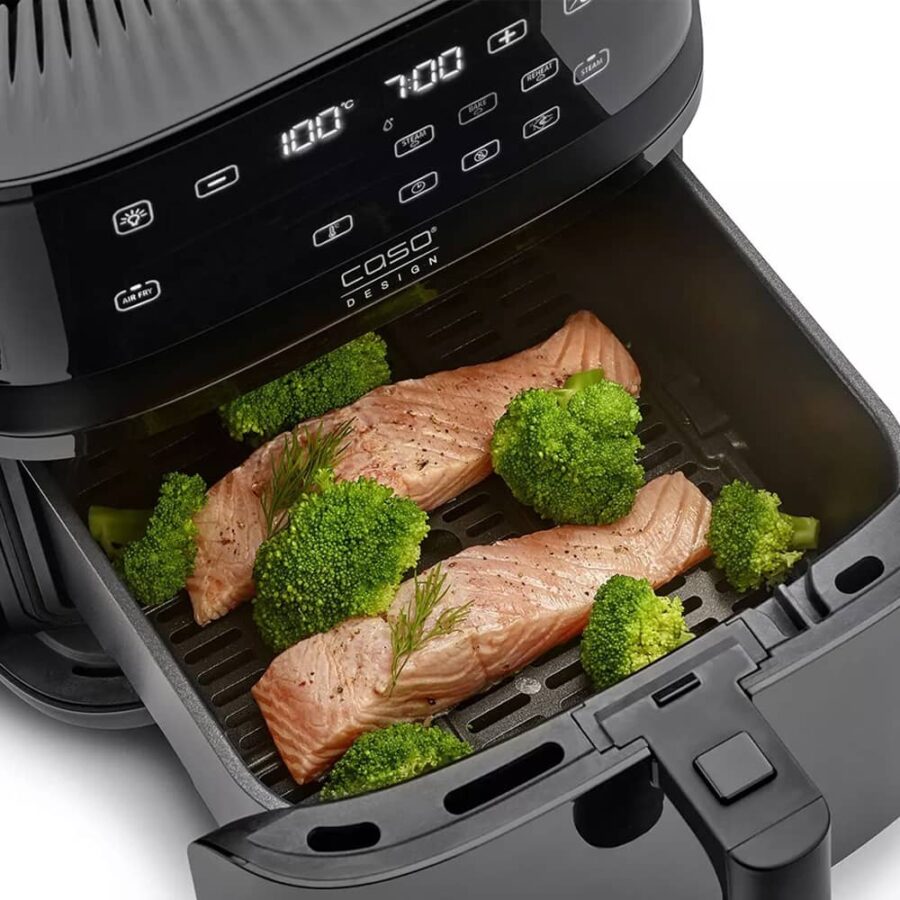 Top view of open Air Fryer Steam 700 drawer with two salmon fillets and broccoli florets inside, close-up shot.
