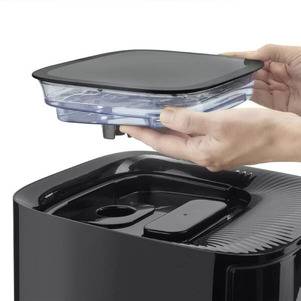 Two hands holding water-filled container for Steam Air Fryer Steam 700, about to place it back into position.