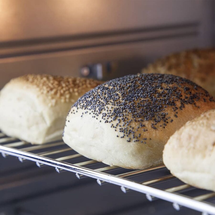 Close-up of bread with chia, black sesame, and regular sesame seeds on wire rack inside CASO TO 26 Electronic Oven.