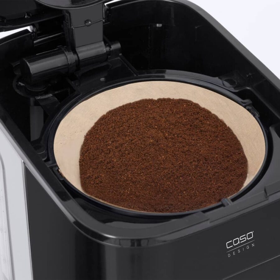 Close-up of coffee powder inside Caso coffee maker machine, showing fine grounds ready for brewing.