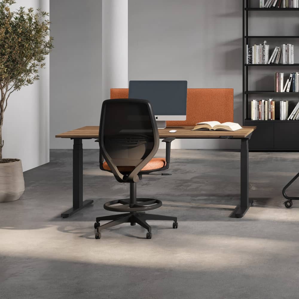 Height adjustable desk with acoustic partition.